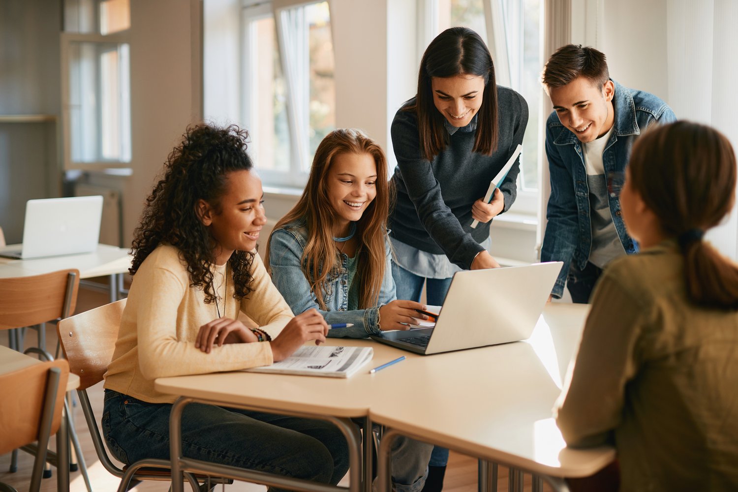 students sitting in front of a laptop learning together students sitting in front of a laptop learning together